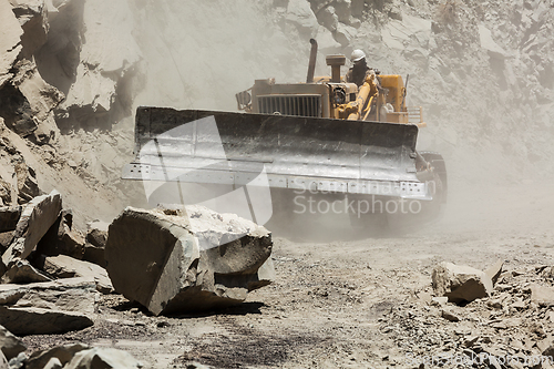 Image of Bulldozer cleaning landslide on road in Himalayas