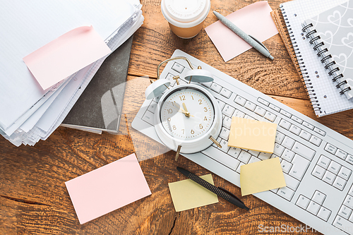 Image of Time management concept. Composition with alarm clock on wooden table with laptop computer, stationary and post-it notes