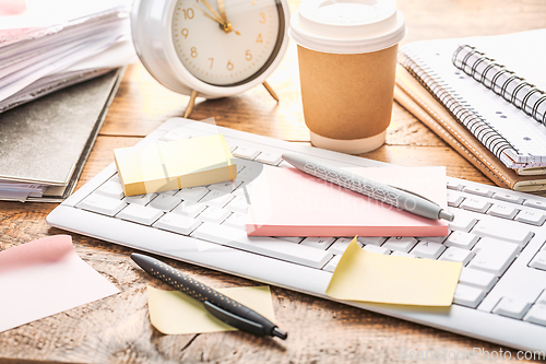 Image of Time management concept. Composition with alarm clock on wooden table with laptop computer, stationary and post-it notes