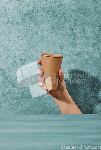 Image of paper coffee cup in human hand