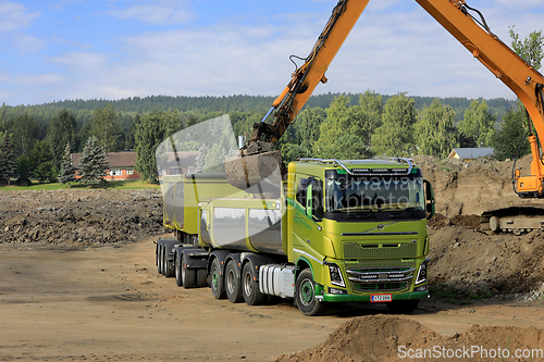 Image of Excavator Loading Soil onto Volvo FH16 Truck Trailer