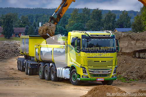 Image of Excavator Loading Soil onto Green Volvo FH16 Truck Trailer