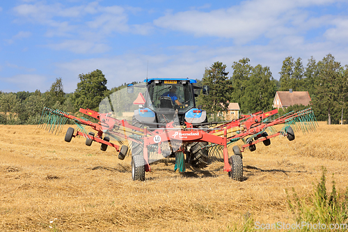 Image of Tractor and Twin Rotary Rake Working in Field 