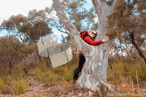 Image of Female hug a grand old gum tree in Australian bushland