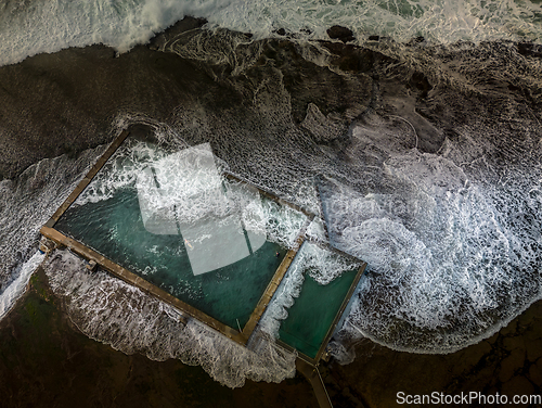 Image of Incoming tide waves crash over the rock pool at Mona Vale