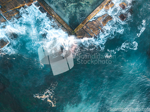 Image of Ocean waves splash onto rocks and into the tidal pool