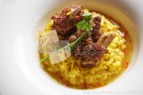 Image of The ossobuco and saffron risotto. Shallow dof