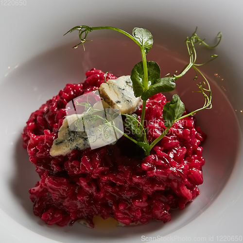 Image of Beetroot risotto with blue cheese on a white plate.