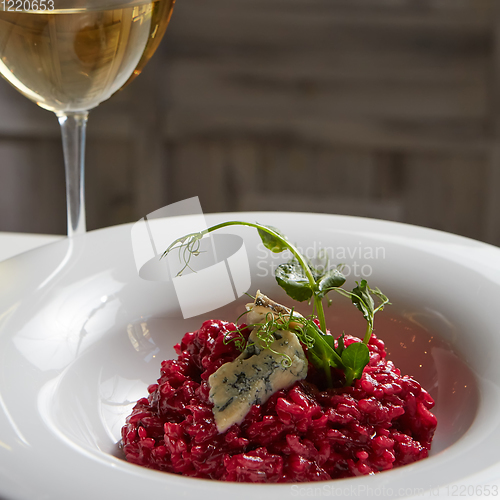 Image of Beetroot risotto with blue cheese on a white plate.