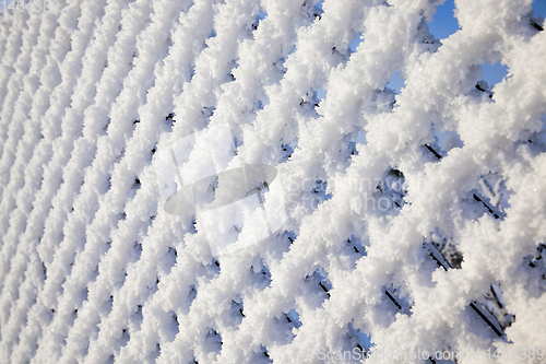 Image of metal fence with snow