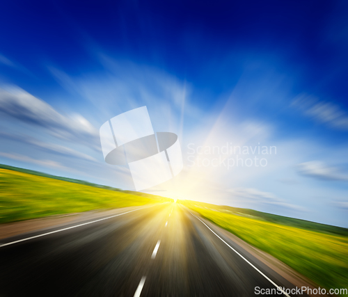 Image of Motion blurred road in blooming spring meadow