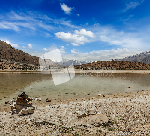 Image of Trekking hiking boots at mountain lake in Himalayas