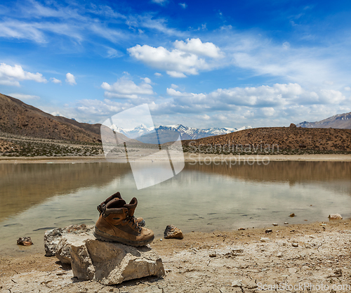 Image of Trekking hiking boots at mountain lake in Himalayas