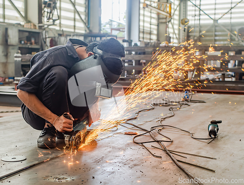 Image of Industrial worker using angle grinder