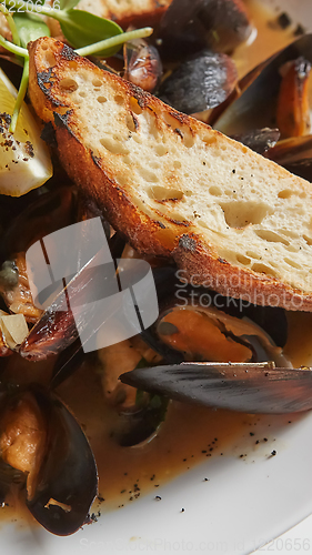 Image of Seafood. Mussels in wine with croutons and lemon. Clams in the shells.