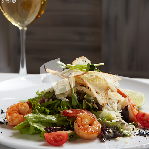 Image of Fresh caesar salad on white bowl with parmesan cheese and shrimp