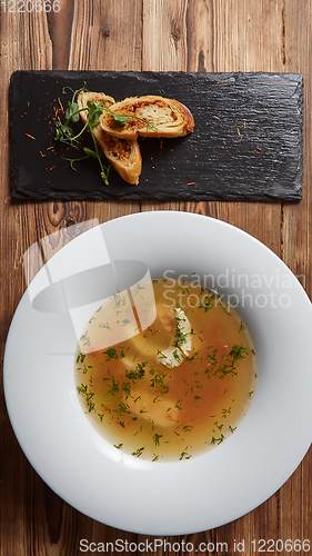 Image of Beautiful presentation of the fish soup in a white plate, with b