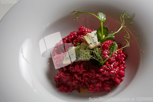 Image of Beetroot risotto with blue cheese on a white plate.