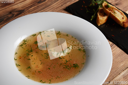 Image of Beautiful presentation of the fish soup in a white plate, with b