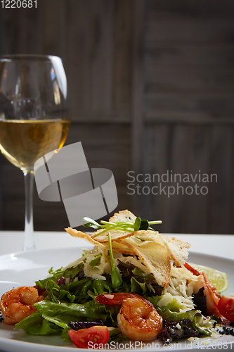 Image of Fresh caesar salad on white bowl with parmesan cheese and shrimp