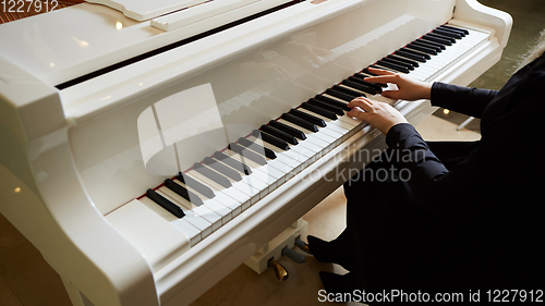 Image of Womans hands on the keyboard of the piano closeup