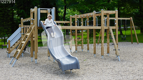 Image of Little girl on a playground. Child playing outdoors in summer. Kids play on school yard.