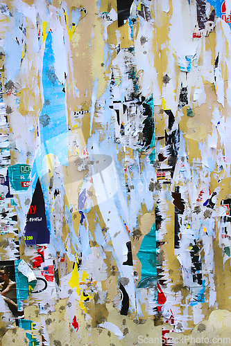 Image of Dirty street yellow wall with old torn and peeling poster paper