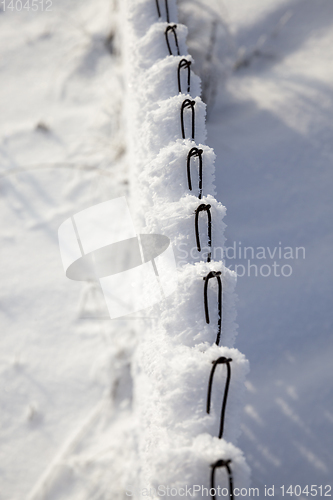 Image of metal fence with snow