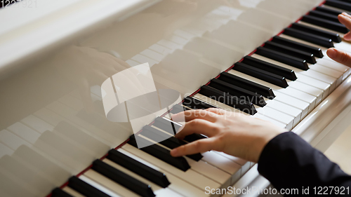 Image of Womans hands on the keyboard of the piano closeup