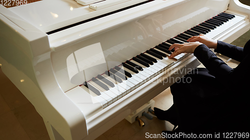 Image of Womans hands on the keyboard of the piano closeup