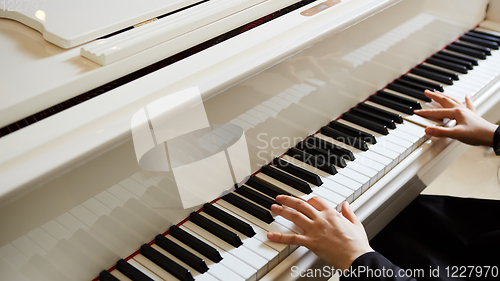 Image of Womans hands on the keyboard of the piano closeup