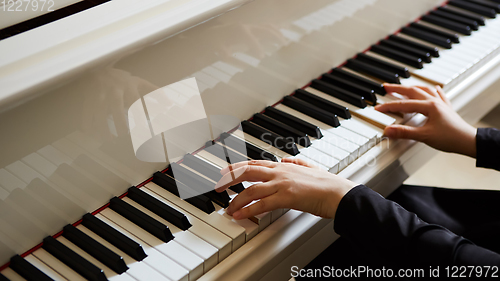 Image of Womans hands on the keyboard of the piano closeup