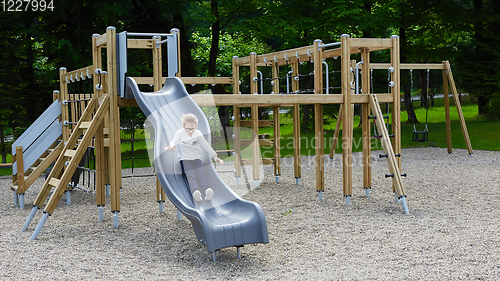 Image of Little girl on a playground. Child playing outdoors in summer. Kids play on school yard.