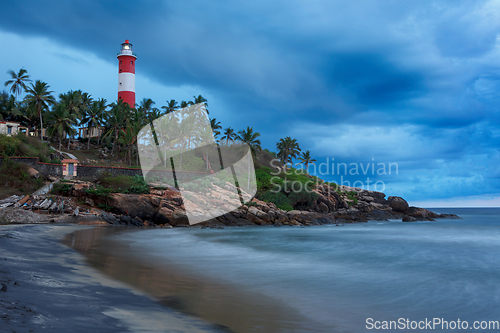 Image of Gathering storm on beach and lighthouse on sunset. Kerala, India