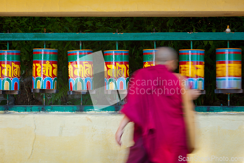 Image of Buddhist monk rotating prayer wheels in McLeod Ganj