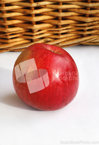 Image of Ripe red appetizing apple on a basket and white background 