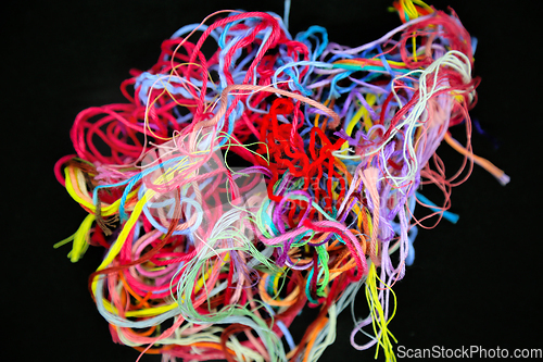 Image of Ball of multicolored tangled threads for needlework on black bac