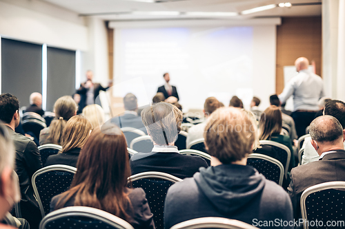 Image of I have a question. Group of business people sitting in conference hall. Businessman raising his arm. Conference and Presentation. Business and Entrepreneurship