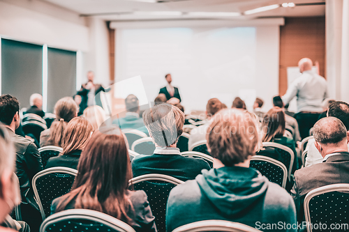 Image of I have a question. Group of business people sitting in conference hall. Businessman raising his arm. Conference and Presentation. Business and Entrepreneurship