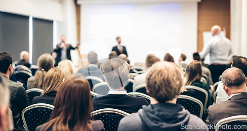 Image of I have a question. Group of business people sitting in conference hall. Businessman raising his arm. Conference and Presentation. Business and Entrepreneurship