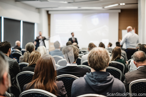 Image of I have a question. Group of business people sitting in conference hall. Businessman raising his arm. Conference and Presentation. Business and Entrepreneurship