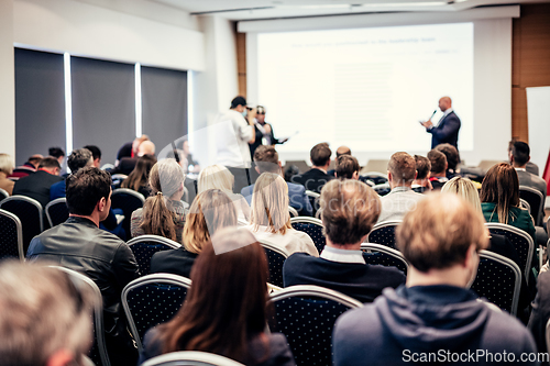 Image of I have a question. Group of business people sitting in conference hall. Businessman raising his arm. Conference and Presentation. Business and Entrepreneurship