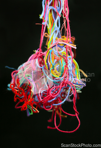 Image of Multicolored tangled threads for needlework on black background