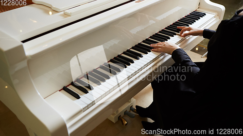 Image of Womans hands on the keyboard of the piano closeup