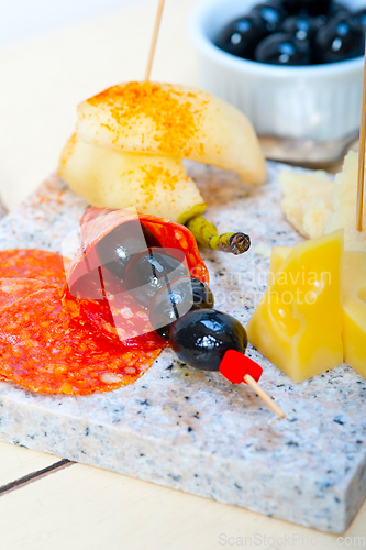 Image of mix cold cut on a stone with fresh pears