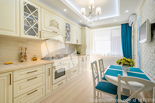 Image of Beige, white and cyan furniture at kitchen in provence style,