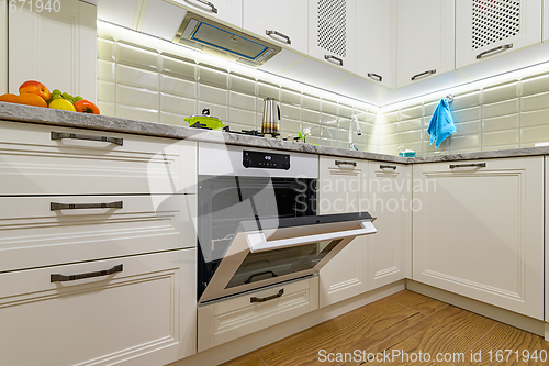 Image of White kitchen in classic style, oven door is open