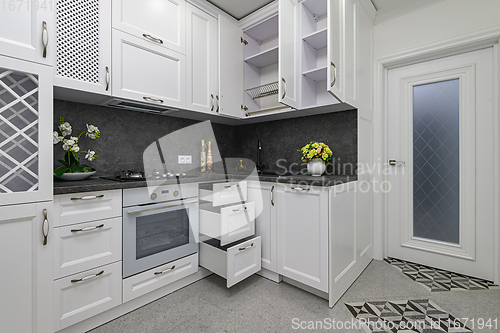 Image of Open doors and drawers open at modern white kitchen