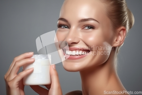 Image of Smiling Young Woman holds cream container