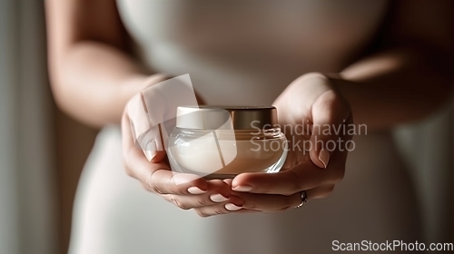 Image of A young woman holds a jar of fresh, natural skin care cream
